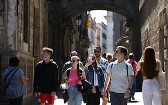 Tourists walk along the Bisbe Street in Barcelona, on May 11, 2022. - Visitors are once again jamming the narrow streets of Barcelona's narrow Gothic quarter as global travel bounces back from the pandemic, reviving concerns over mass tourism in the Spanish port city. (Photo by LLUIS GENE / AFP) (Photo by LLUIS GENE/AFP via Getty Images)