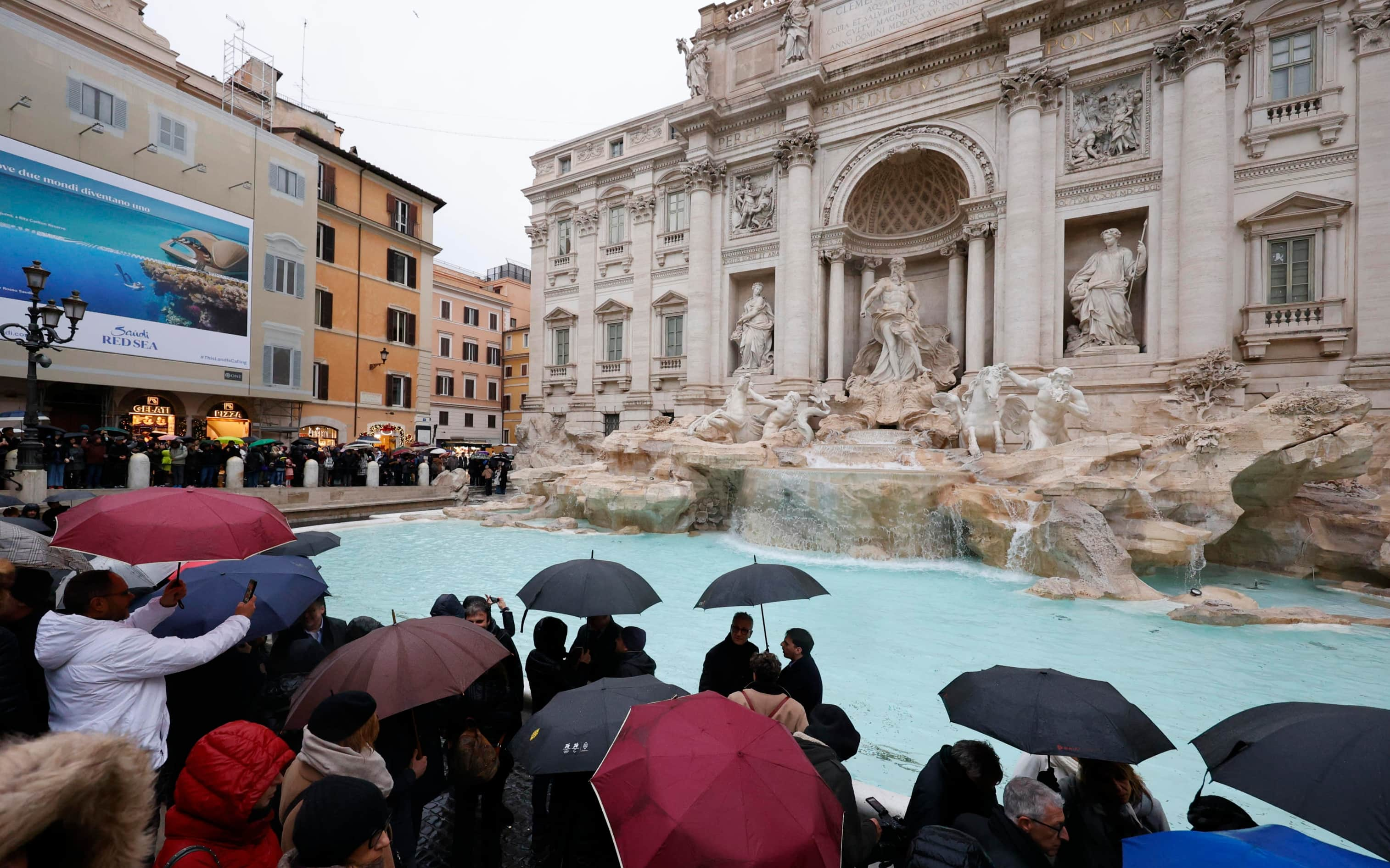 People look the 18th century Trevi Fountain as it reopens to the public after undergoing maintenance, Rome 22 December 2024. ANSA/FABIO FRUSTACI