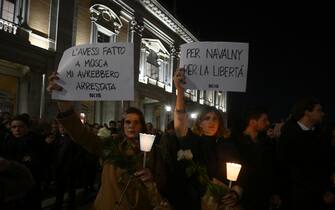 Women hold candles and posters reading 'If I had did it in Moscow they will have put me under arrest' ' for Navalny, for freedom' during a vigil in honor of Kremlin's critic Alexei Navalny following is death, on February 19, 2024 in front of Rome's city hall. Russia reported Navalny's death in an arctic prison on February 16, 2024 and his mother has been denied access to the body, enraging supporters who have accused authorities of trying to cover up Navalny's "murder". (Photo by Filippo MONTEFORTE / AFP) (Photo by FILIPPO MONTEFORTE/AFP via Getty Images)