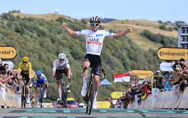 epa10762373 White Jersey best young rider Slovenian rider Tadej Pogacar of team UAE Team Emirates celebrates as he crosses the finish line to win the 20th stage of the Tour de France 2023, a 134kms from Belfort to Le Markstein Fellering, France, 22 July 2023.  EPA/CHRISTOPHE PETIT TESSON