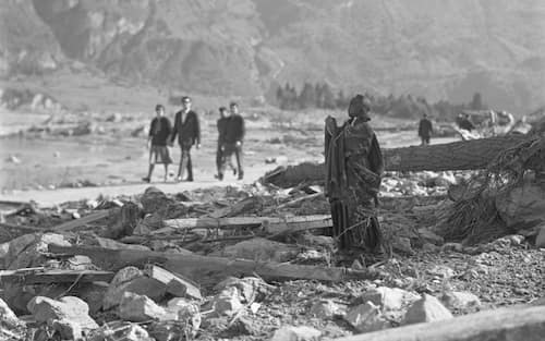 People walk past a lone, standing statue among the ruins, Longarone, near the Vajont Dam in the Piave Valley, Italy, early October, 1963. On October 9, a landslide in the dam basin caused a wave more than 800 feet high to overtop the dam and flood the valley below--five villages were completely destroyed, more than 2000 people were killed, and thousands more were left homeless and displaced. (Photo by Archivio Cameraphoto Epoche/Getty Images)