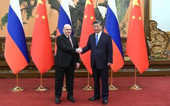 epa10649487 Russian Prime Minister Mikhail Mishustin (L) and Chinese President Xi Jinping shake hands during a meeting at the Great Hall of the People, in Beijing, China, 24 May 2023.  EPA/DMITRY ASTAKHOV / SPUTNIK / GOVERNMENT PRESS SERVICE POOL MANDATORY CREDIT