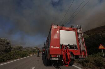 Firefighters attempt to extinguish a section of the wildfire on the Greek island of Rhodes, on July 26, 2023. Greece is currently grappling with rampant wildfires fueled by sweltering heat, leading to extensive evacuations in various tourist destinations, notably the islands of Rhodes and Corfu. (Photo by STR/NurPhoto via Getty Images)