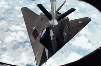An F-117A Stealth fighter en route to the Middle East and a supporting role in Operation Desert Shield, is refueled by a KC-135 Stratotanker somewhere over Kansas, August 19, 1990. Approximately 20 of the formerly secret fighters left their base at Tonopah Test Range Airfield, Nevada to join the growing American military presence in the Persian Gulf. | Location: above Kansas, USA.