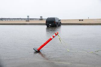 epa10811125 A car is parked in a flooded parking lot in Seal Beach, California, USA, 20 August 2023. Southern California is under a tropical storm warning for the first time in history as Hilary makes landfall. The last time a tropical storm made landfall in Southern California was 15 September 1939, according to the National Weather Service.  EPA/CAROLINE BREHMAN