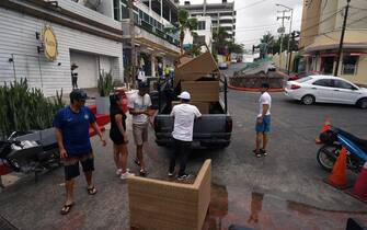 Employees of a restaurant take away the furnitures before the arrival of hurricane Hilary at Los Cabos resort in Baja California state, Mexico on August 18, 2023. Hurricane Hilary strengthened into a major storm in the Pacific on Friday and was expected to further intensify before approaching Mexico's Baja California peninsula over the weekend, forecasters said. (Photo by ALFREDO ESTRELLA / AFP) (Photo by ALFREDO ESTRELLA/AFP via Getty Images)