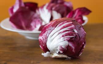 Subject: A head of radicchio and a plate of radicchio leaves on a kitchen table