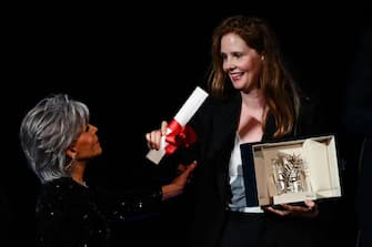 French director Justine Triet (R) celebrates on stage with US actress Jane Fonda after she won the Palme d'Or for the film "Anatomie d'une Chute" (Anatomy of a Fall) during the closing ceremony of the 76th edition of the Cannes Film Festival in Cannes, southern France, on May 27, 2023. (Photo by CHRISTOPHE SIMON / AFP) (Photo by CHRISTOPHE SIMON/AFP via Getty Images)