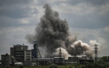 TOPSHOT - Smoke and dirt ascends after a strike at a factory in the city of Soledar at the eastern Ukranian region of Donbas on May 24, 2022, on the 90th day of the Russian invasion of Ukraine. (Photo by ARIS MESSINIS / AFP)