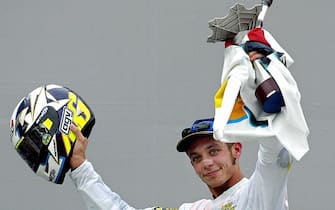 SEPANG, MALAYSIA:  Valentino Rossi of Italy celebrates with his trophy after winning the Malaysian Motorcycle Grand Prix in Sepang 12 October 2003. Rossi won the race with a time of 43:41.457 to become the World MotoGP Champion, his third championship in a row.  AFP PHOTO / Jimin LAI  (Photo credit should read JIMIN LAI/AFP via Getty Images)