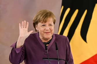 epa10577212 Former German Chancellor Angela Merkel waves while speaking after she was awarded the 'Grand Cross of the Order of Merit of the Federal Republic of Germany' by German President Frank-Walter Steinmeier (unseen) during a ceremony in Berlin, Germany, 17 April 2023.  EPA/FILIP SINGER