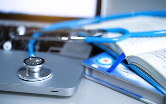 Medical stethoscope with books and laptop