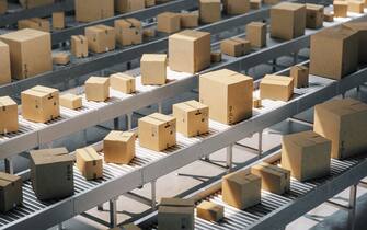 Cardboard boxes on conveyor belt in a distribution warehouse.