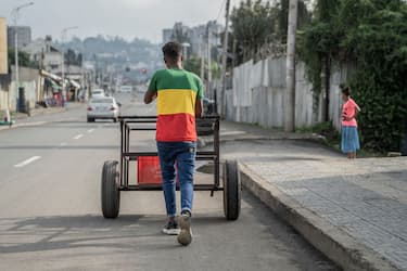 A man wearing a shirt bearing the colors of the Ethiopian flag, pushes a cart during Enkutatash, the Ethiopian New Year holiday in Addis Ababa, Ethiopia, on September 11, 2022. - Enkutatash is a public holiday in coincidence of New Year in Ethiopia and Eritrea. It occurs on Meskerem 1 on the Ethiopian calendar, which is 11 September according to the Gregorian calendar. (Photo by Amanuel Sileshi / AFP) (Photo by AMANUEL SILESHI/AFP via Getty Images)