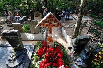 epa10828040 People visit the grave of PMC Wagner group founder and chief Yevgeny Prigozhin at the Porokhov cemetery in St. Petersburg, Russia, 30 August 2023. Yevgeny Prigozhin was buried on 29 August near his father's grave during a quiet ceremony at the Porokhov cemetery on the outskirts of St. Petersburg, despite heightened security at the Serafimovskoe Cemetery, where his burial was allegedly expected to take place. Russian authorities on 27 August confirmed that Prigozhin died along with nine others in the crash of an aircraft in the Tver region of Russia on 23 August 2023.  EPA/STRINGER