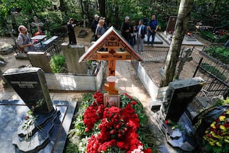 epa10828040 People visit the grave of PMC Wagner group founder and chief Yevgeny Prigozhin at the Porokhov cemetery in St. Petersburg, Russia, 30 August 2023. Yevgeny Prigozhin was buried on 29 August near his father's grave during a quiet ceremony at the Porokhov cemetery on the outskirts of St. Petersburg, despite heightened security at the Serafimovskoe Cemetery, where his burial was allegedly expected to take place. Russian authorities on 27 August confirmed that Prigozhin died along with nine others in the crash of an aircraft in the Tver region of Russia on 23 August 2023.  EPA/STRINGER