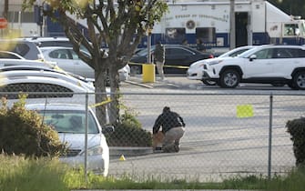 epa10423321 A Crime Scene technician collects evidence in a parking lot after a mass shooting at a dance studio in Monterey Park, California, USA, 22 January 2023. The shooting killed ten and wounded ten more during a Lunar New Year celebration according to the Los Angeles County Sheriff's Department.  EPA/DAVID SWANSON