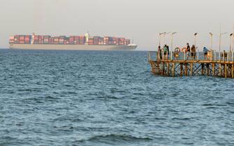 epa06958960 Egyptians enjoy the sea as a cargo ship crosses the Gulf of Suez towards the Red Sea at El Sokhna beach in Suez, Egypt, 130 km east of Cairo, Egypt, 19 August 2018  EPA/KHALED ELFIQI