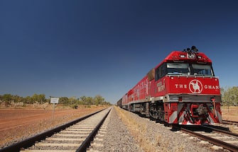 KATHERINE, AUSTRALIA - AUGUST 04: (EDITORS NOTE: A POLARIZING FILTER WAS USED IN THE CREATION OF THIS IMAGE). The Ghan waits in Katherine train station on August 4, 2009 in Northern Territory, Australia. The commemorative trip from Adelaide to Darwin celebrates the 80th anniversary of The Ghan's travel through the heart of Australia alongside 80 years of the Australian Red Cross Blood Service. The Ghan first departed Adelaide bound for Alice Springs in August 1929, initially as a vitial outback transport link to the Red Centre, with this year's trip aiming to thank those who have given their support to the route over the past 80 years.  (Photo by Mark Metcalfe/Getty Images)