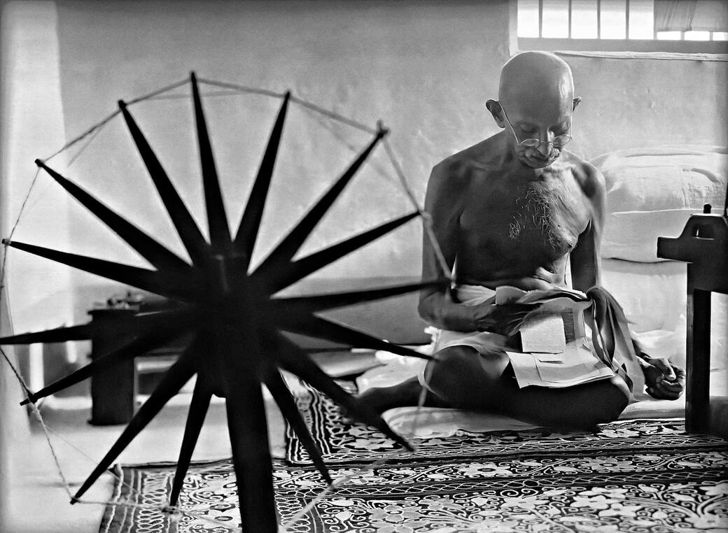 Margaret Bourke-White, Mohandas Karamchand Gandhi mentre legge vicino a un arcolaio nella sua casa di Pune. Maharashtra, India, 1946. Margaret Bourke-White/The LIFE Picture Collection/Shutterstock