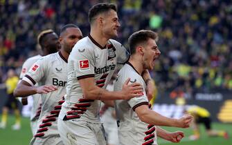 epa11292388 Leverkusen's Josip Stanisic (R) celebrates with teammates after scoring the 1-1 equalizer during the German Bundesliga soccer match between Borussia Dortmund and Bayer 04 Leverkusen in Dortmund, Germany, 21 April 2024.  EPA/CHRISTOPHER NEUNDORF CONDITIONS - ATTENTION: The DFL regulations prohibit any use of photographs as image sequences and/or quasi-video.