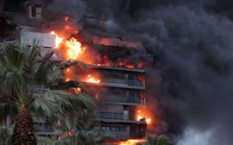 epa11173271 Smoke rises from a fire of a 14-story residential building in Valencia, eastern Spain, 22 February 2024. At least seven people were injured during the ongoing fire, and two people trapped on a balcony were rescued by firefighters.  EPA/MANUEL BRUQUE