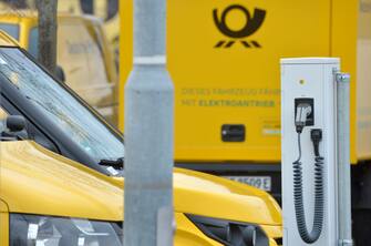 01 April 2021, Saxony, Leipzig: "This vehicle runs on electric power". Several of Deutsche Post's StreetScooter electric transporters stand at charging stations at a DHL site in Leipzig. Photo: Volkmar Heinz/dpa-Zentralbild/ZB (Photo by Volkmar Heinz/picture alliance via Getty Images)