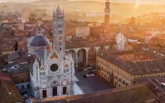 View on the Cathedral of the medieval town of Siena, left, and the "Il Mangia" main town, right, on sunrise during the lockdown emergency period aimed at stopping the spread of the Covid-19 coronavirus. Although the lockdown and full absence of people, the scenery of the Italian squares and monuments remain fascinating, Siena, Italy, 23 April 2020
(ANSA foto Fabio Muzzi)