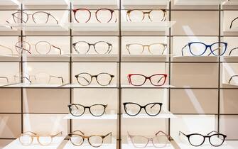 Rack with frames for glasses in optician shop. Variety of eyeglasses frames on store display.