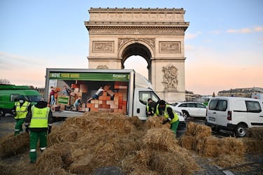 PARIS, FRANCE - MARCH 01: City workers clear the road in front of the Arc de Triomphe on the Champs-Elysees after a protest by the French farmers' union in Paris, France on March 1, 2024. (Photo by Mustafa YalÃ§n/Anadolu via Getty Images)