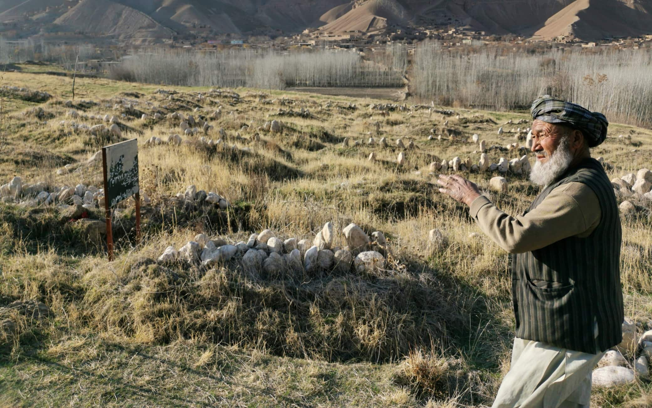 Qush Tepah - An Afghan man in front of the grave of his wife and his niece, killed during a Nato raid.