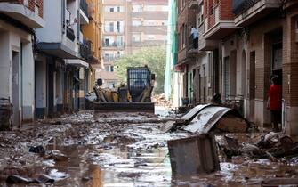 epa11693919 A bulldozer clears mud from a street in the flood-hit Municipality of Catarroja, Valencia, Spain, 31 October 2024. The intense rainfall impacting the eastern part of the country resulted in at least 95 lives being lost in the province of Valencia and neighboring provinces due to the flooding. The State Meteorological Agency (AEMET) has issued red alerts for rainfall in multiple regions of the province of Valencia, caused by the severe storm DANA.   EPA/MANUEL BRUQUE