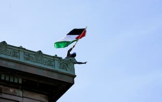 epaselect epa11311442 A pro-Palestine protester on the roof of Hamilton Hall at Columbia University after protesters barricaded themselves in the building earlier in the day in New York, New York, USA, 30 April 2024. Students have been protesting the university's investments in Israel and showing their support for Palestine for over two weeks, also inspiring other students nationwide to do the same.  EPA/STEPHANI SPINDEL