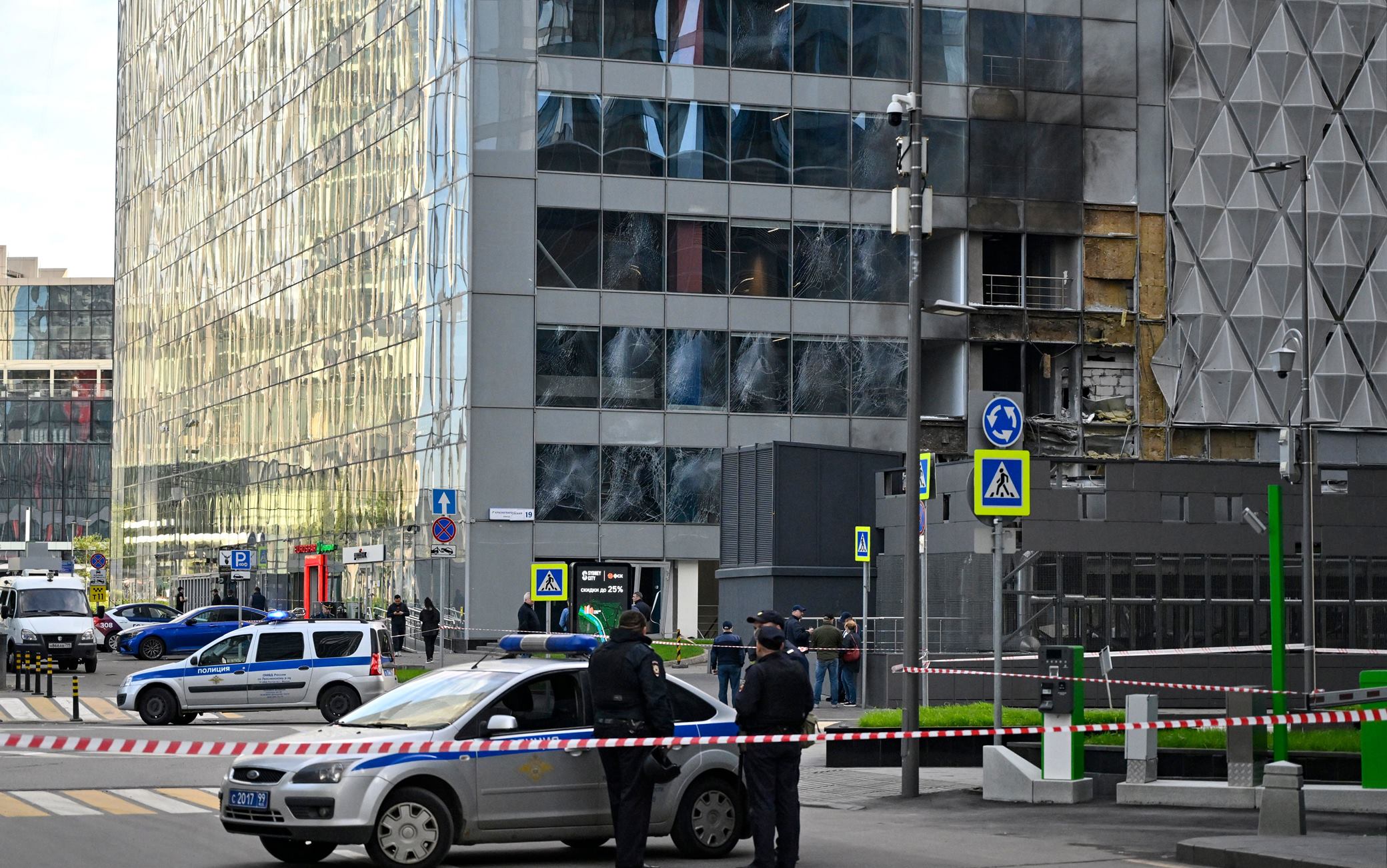 Police officers block off an area around a damaged office block of the Moscow International Business Center (Moskva City) following a reported drone attack in Moscow on July 30, 2023. Three Ukrainian drones were downed over Moscow early on July 30, 2023, Russia's defence ministry said, in an attack that briefly shut an international airport. While one of the drones was shot down on the city's outskirts, two others were "suppressed by electronic warfare" and smashed into an office complex. No one was injured. (Photo by Alexander NEMENOV / AFP) (Photo by ALEXANDER NEMENOV/AFP via Getty Images)