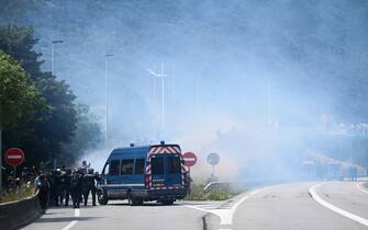 Gendarmes stand near tear gas smoke during clashes with protesters during a demonstration against the construction of a high-speed rail line between Lyon and Torino, in La Chapelle, near Modane, in the French Alps' Maurienne valley, on June 17, 2023. Hundreds of oponents to the Lyon-Torino high-speed rail line demonstrated on June 17 despite a ban on the gathering, of which the details are yet to be determined and despite a heavy police presence in the valley. They set up a makeshift camp on land lent by the municipality of La Chapelle, outside the ban zone announced the day before by the Savoie prefecture. (Photo by OLIVIER CHASSIGNOLE / AFP) (Photo by OLIVIER CHASSIGNOLE/AFP via Getty Images)