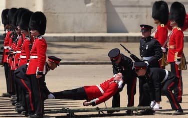 A member of the Grenadier Guards is carried after fainting during the Colonel's Review at Horse Guards Parade in London on June 10, 2023 ahead of The King's Birthday Parade. The Colonel's Review is the final evaluation of the parade before it goes before Britain's King Charles III during the Trooping of the Colour on June 17. (Photo by Adrian DENNIS / AFP) (Photo by ADRIAN DENNIS/AFP via Getty Images)