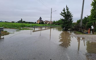 Allagamenti a Padova, una mamma con il suo bambino percorre con gli stivali un tratto di strada sommerso dall'acqua, nella zona di Padova est 