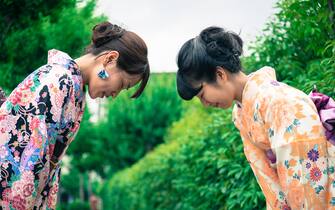 Portrait of beautiful japanese women in kimono bowing to each other in Gion, Kyoto, Japan. Waist up, side view. Copy space. Nikon D800, full frame, XXXL. iStockaLypse Kyoto 2016.