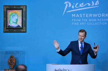 Sotheby's auctioneer Oliver Barker leads an auction of 11 works by Spanish artist Pablo Picasso from the MGM Resorts Fine Art Collection, alongside "Femme au beret rouge-orange" (top L) sold for $40.4 million, in Las Vegas on October 23, 2021. - RESTRICTED TO EDITORIAL USE - MANDATORY MENTION OF THE ARTIST UPON PUBLICATION - TO ILLUSTRATE THE EVENT AS SPECIFIED IN THE CAPTION (Photo by Ronda Churchill / AFP) / RESTRICTED TO EDITORIAL USE - MANDATORY MENTION OF THE ARTIST UPON PUBLICATION - TO ILLUSTRATE THE EVENT AS SPECIFIED IN THE CAPTION / RESTRICTED TO EDITORIAL USE - MANDATORY MENTION OF THE ARTIST UPON PUBLICATION - TO ILLUSTRATE THE EVENT AS SPECIFIED IN THE CAPTION (Photo by RONDA CHURCHILL/AFP via Getty Images)