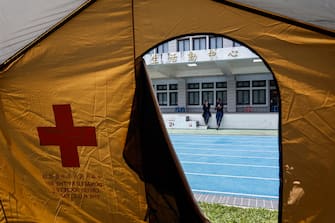 epa11258199 Two men chat in front of one of the tents donated by the Red Cross Society of the Republic of China (ROC) Taiwan set up at a primary-school-turned shelter following the 03 April magnitude 7.4 earthquake in Hualien, Taiwan, 04 April 2024. The strongest earthquake in 25 years, with multiple aftershocks, has taken at least nine lives and injured more than a thousand people while causing nationwide damages to structures and buildings. Schools or businesses in some parts of the island have been suspended.  EPA/DANIEL CENG