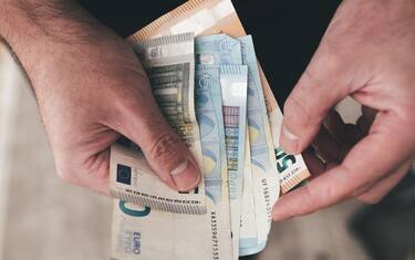 top down view of hands of man holding euro bills, counting money