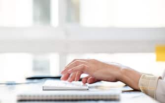 Woman hands typing on computer keyboard on the table