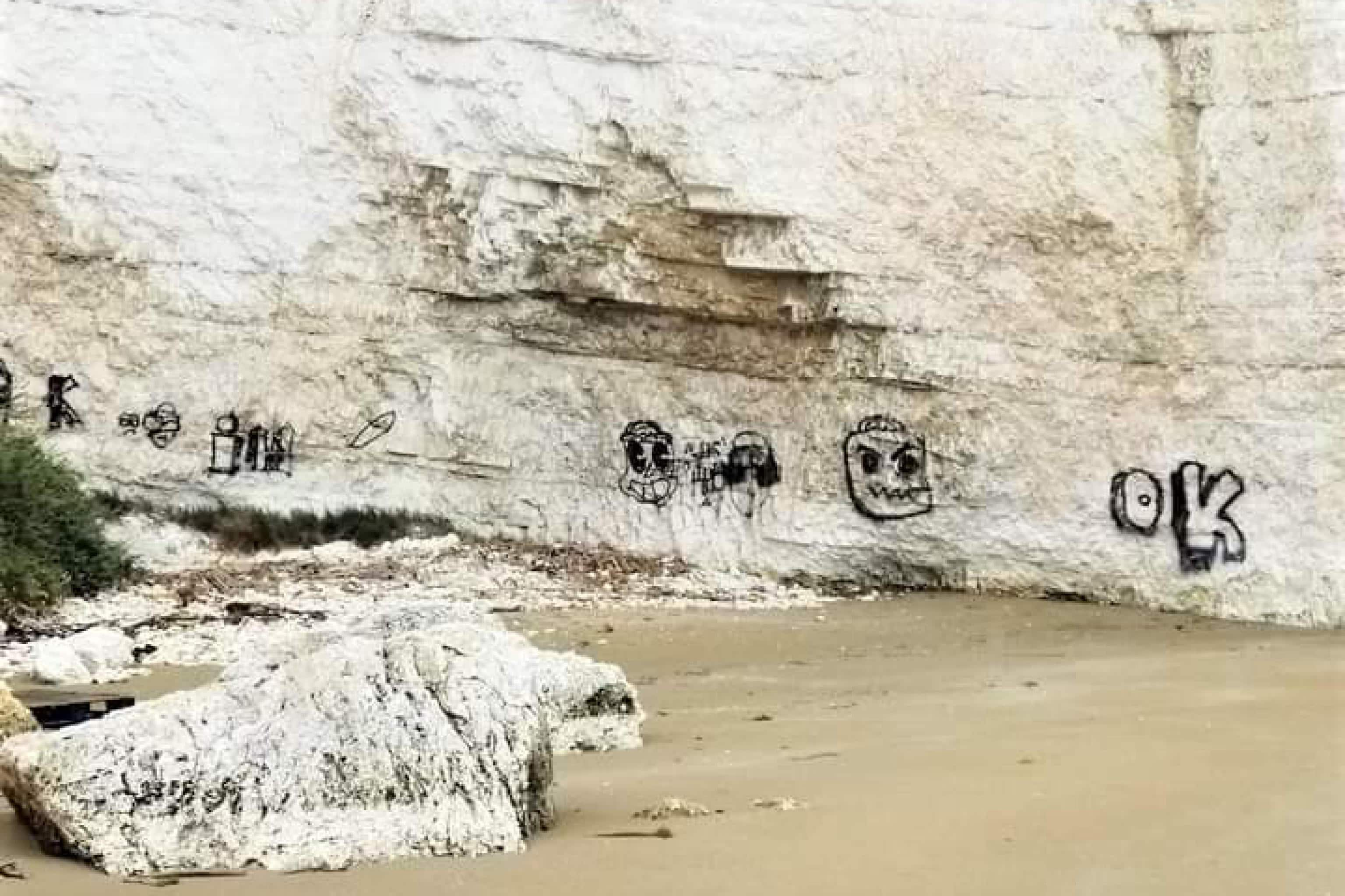 La parete rocciosa che si trova alle spalle del Pizzomunno, il monolite che svetta sul lungomare di Vieste (Foggia) è stata imbrattata con della vernice spray di colore nero. 22 marzo 2023.
ANSA/Franco  Cautillo