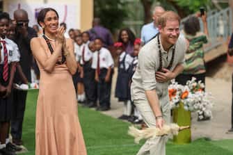 TOPSHOT - Britain's Prince Harry (R), Duke of Sussex, and Britain's Meghan (L), Duchess of Sussex, take part in activities as they arrive at the Lightway Academy in Abuja on May 10, 2024 as they visit Nigeria as part of celebrations of Invictus Games anniversary. (Photo by Kola SULAIMON / AFP) (Photo by KOLA SULAIMON/AFP via Getty Images)