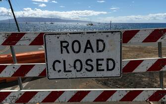 epa10802238 A sign reads 'Road Closed' in Lahaina, Hawaii, USA, 15 August 2023. At least 99 people were killed in the Lahaina wildfire that burnt in Maui, which is considered the largest natural disaster in Hawaii's state history.  EPA/ETIENNE LAURENT