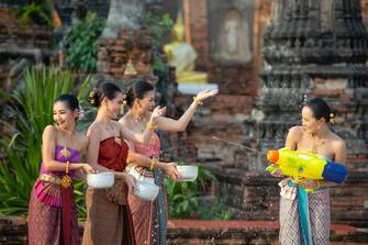 Thailand culture. Women play water in Songkran festival with Thai Traditional costume in the temple of Ayutthaya Thailand.
