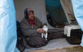 KAHRAMANMARAS, TURKIYE - FEBRUARY 24: Medine Bunsuz, an earthquake survivor lives the tent city established in Vali Saim Cotur Stadium and around with her cat named "Mino" after 7.7 and 7.6 magnitude earthquakes hit multiple provinces of Turkiye including Kahramanmaras on February 24, 2023. Some survivors of earthquakes in Kahramanmaras live together in a tent city with their animals, such as fish, birds, partridges, cats and dogs, which they rescued while leaving their homes. Established by the Sakarya 7th Commando Brigade Command, the tent city hosts nearly 3,500 earthquake victims as well as dozens of pets. (Photo by Fatih Kurt/Anadolu Agency via Getty Images)