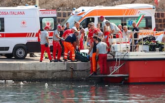 Ambulances with health workers wait on the pier to rescue the seven missing people who were on board the sailing boat that sank at dawn this morning in Palermo, Sicily, Italy,  19 August  2024. A 56-meter-long luxury sailboat, the Bayesian, with 22 people on board, sank at dawn on Monday off Porticello, near Palermo, after a tornado hit the area. At least six missing, one dead in Palermo shipwreck 
ANSA/IGOR PETYX