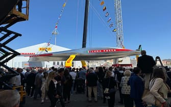 Varata la nuova Ac75 di Luna Rossa a Cagliari, 13 aprile 2024. Con la benedizione del vescovo Giuseppe Baturi è scattato alle 13.23 il via alla nuova avventura della barca che cercherà di portare in Italia la Coppa America. La madrina dell'inaugurazione è stata come al solito Miuccia Prada accompagnata dal patron Patrizio Bertelli. Poi la fatidica frase 'Io ti battezzo Luna Rossa'. Con la bottiglia di spumante che si è schiantata sulla scocca argentata della nuova barca dai colori argento, grigio e rosso con due ali gialle che la faranno "volare" sull'acqua. Uno scafo molto affusolato per affrontare meglio le onde.
ANSA/ ROBERTA CELOT