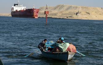 ISMAILIA, EGYPT - JANUARY 10: A small boat is seen as a ship transits the Suez Canal towards the Red Sea on January 10, 2024 in Ismailia, Egypt. In the wake of Israel's war on Gaza after the October 7 Hamas attack on Israel, Houthi rebels in Yemen pledged disruption on all ships destined for Israel through the Red Sea's Suez Canal. The disruption on world trade is evident in the number of companies using this container ship route - a 90 per cent decline compared to figures one year ago. (Photo by Sayed Hassan/Getty Images)